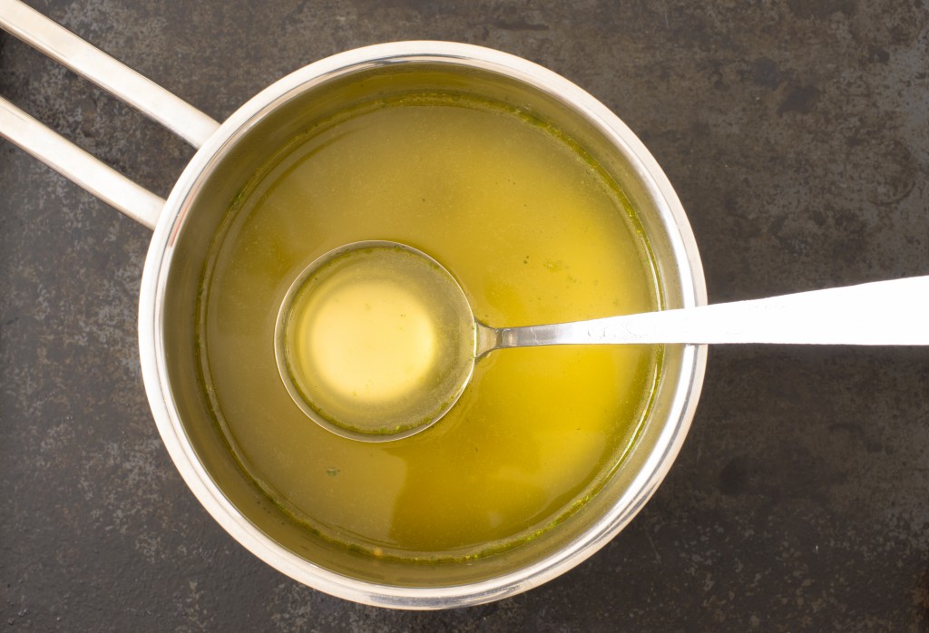 Broth in a steel pot on the stove mixed with butter for basting turkey thanksgiving recipe