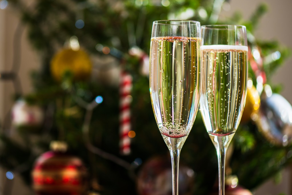Two Champagne Flutes on Christmas Background with Xmas Tree